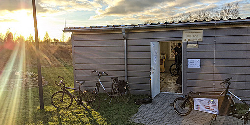 fahrräder im Sonnenlicht vor dem Rigacontainer
